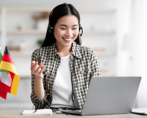 happy-asian-lady-using-laptop-and-headset-learning-foreign-language.jpg